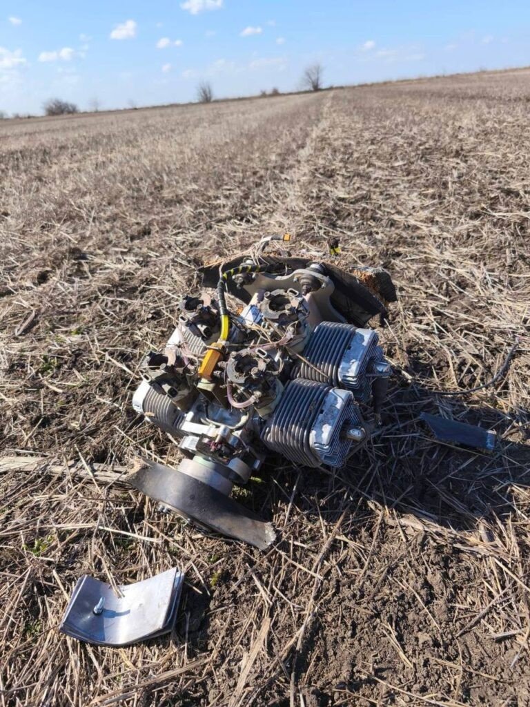 Поршневой двигатель дрона Shahed с рёбрами воздушного охлаждения, отделившийся от корпуса при падении. Видны провода и элементы крепления