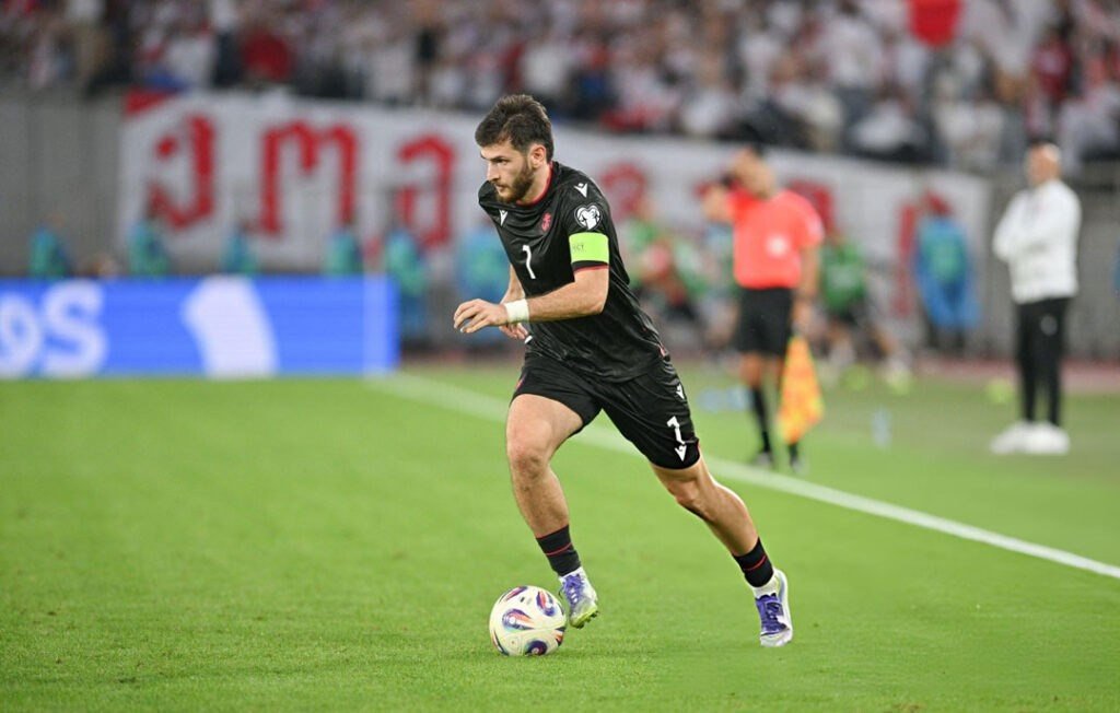 Игрок сборной Грузии ведёт мяч во время матча в форме национальной команды