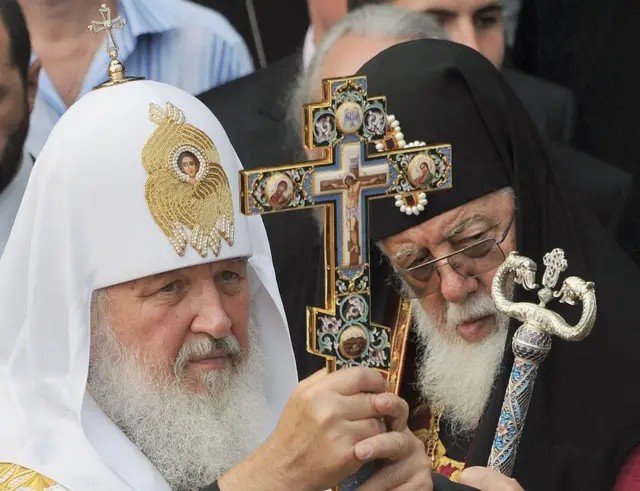 Патриарх Кирилл и Патриарх Илия II на совместном церковном мероприятии с украшенным крестом