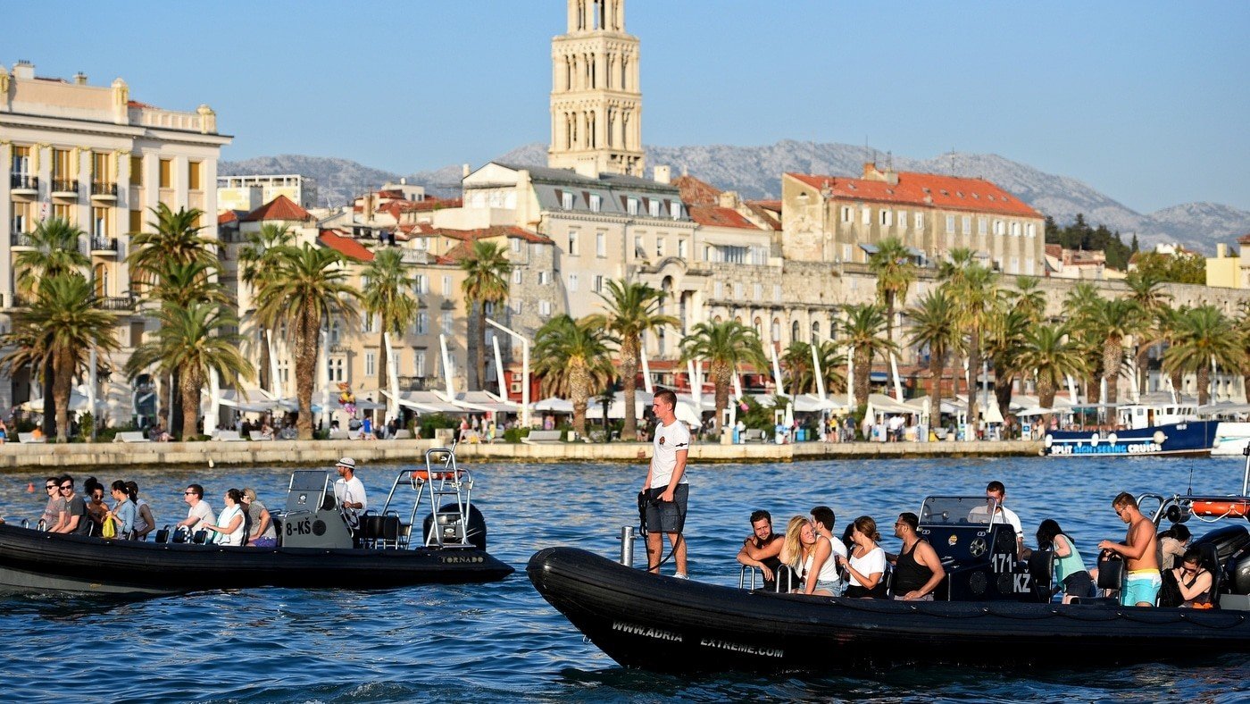 Набережная Сплита с прогулочными катерами и туристами на фоне колокольни Диоклетианова дворца