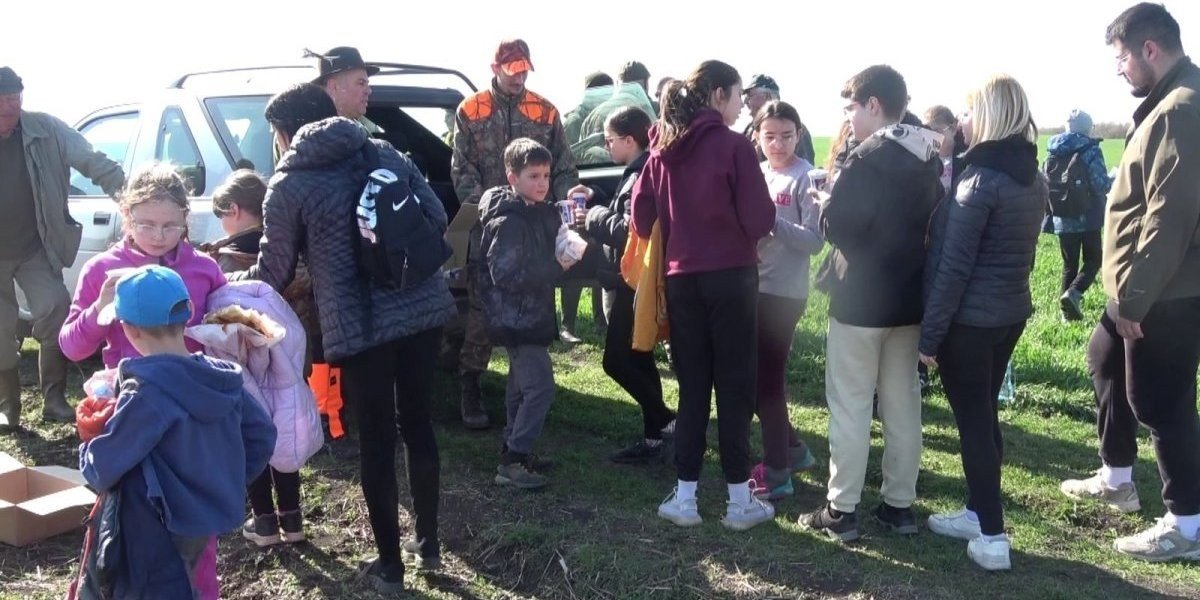 Дети и взрослые у машин на краю поля перед началом акции подсчёта зайцев