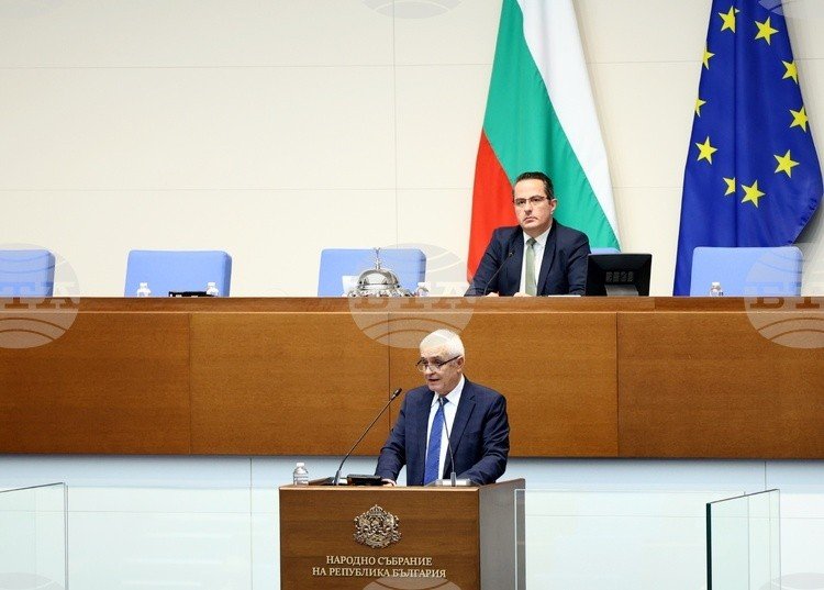 Заседание Народного собрания Республики Болгарии. На трибуне — выступающий депутат на фоне флагов Болгарии и Европейского союза