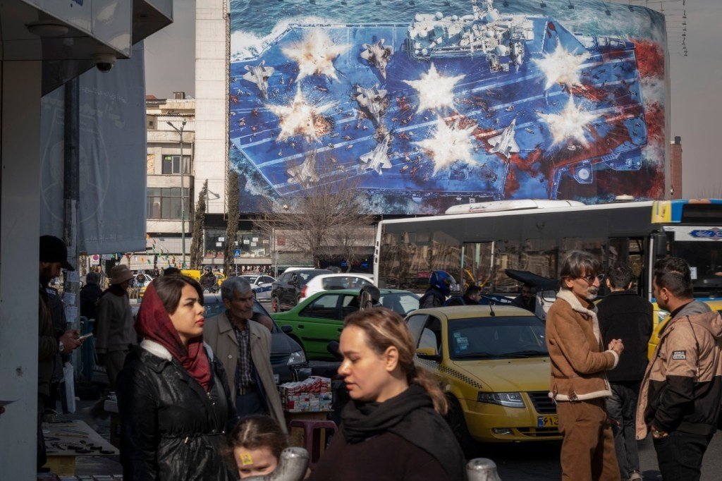 Улица Тегерана с антиамериканским пропагандистским муралом на фоне повседневной жизни горожан