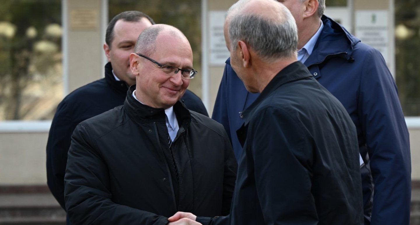 Российские чиновники во время визита в Абхазию — рукопожатие перед зданием администрации