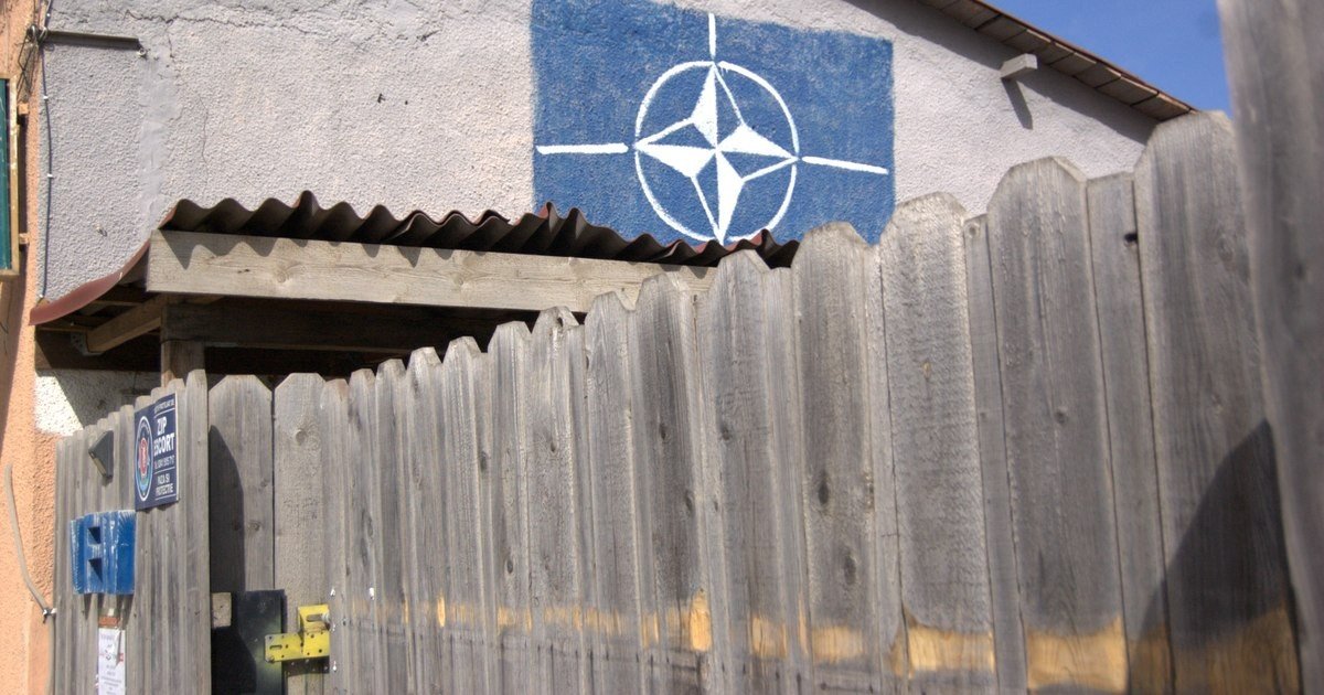 Символ НАТО — компасная роза, нарисованная на стене здания рядом с деревянным забором в селе Михаил Когэлничану