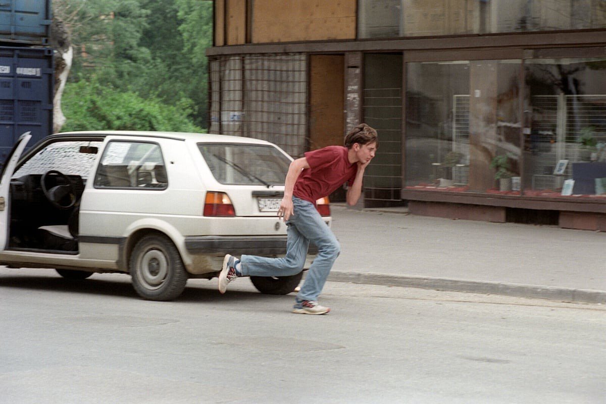 Молодой человек перебегает улицу в Сараево, спасаясь от снайперского огня во время осады — так называемая «Аллея снайперов»