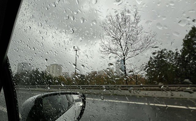 Сильный дождь в Болгарии — капли на лобовом стекле автомобиля на мокрой трассе