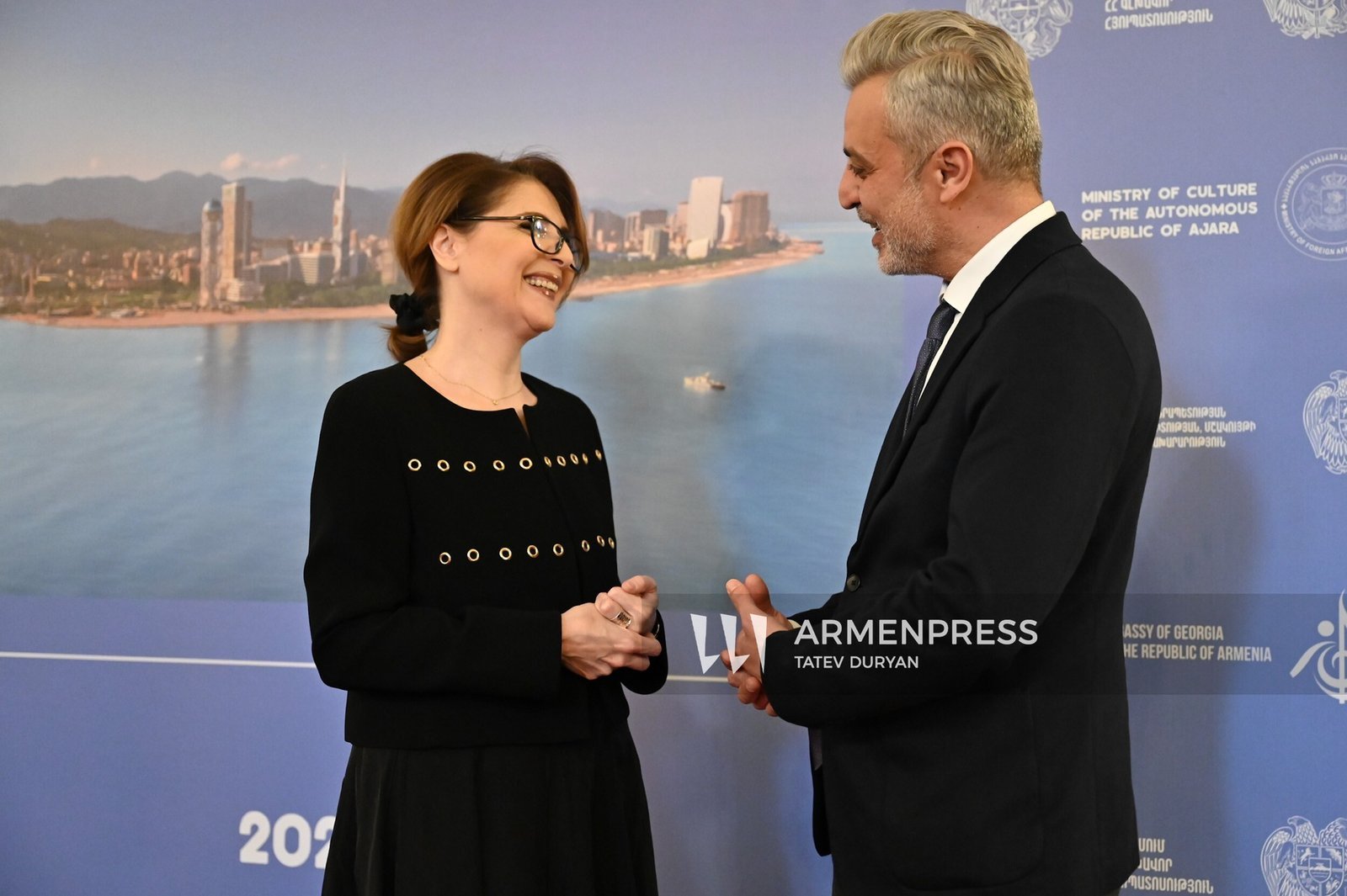 Министр культуры Аджарии Элисо Болквадзе в беседе с армянским коллегой на фоне баннера культурной программы «Музыкальный Батуми» в Ереване