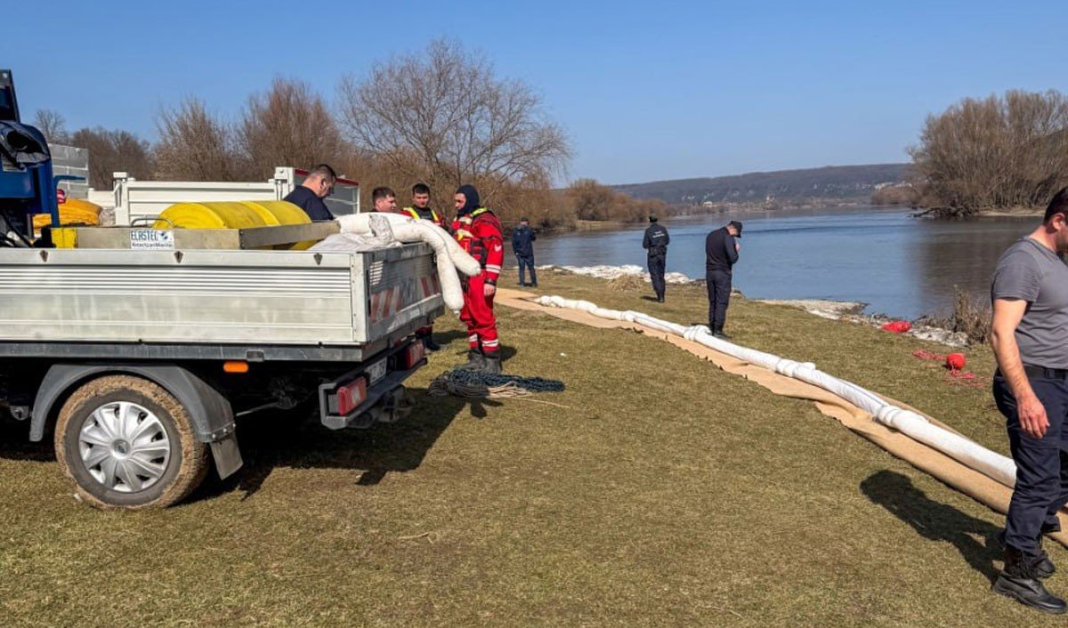 Спасатели разгружают абсорбирующие материалы из грузовика на берегу Днестра для установки фильтрационных заграждений