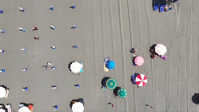 Пляж с зонтиками и отдыхающими, вид сверху с дрона