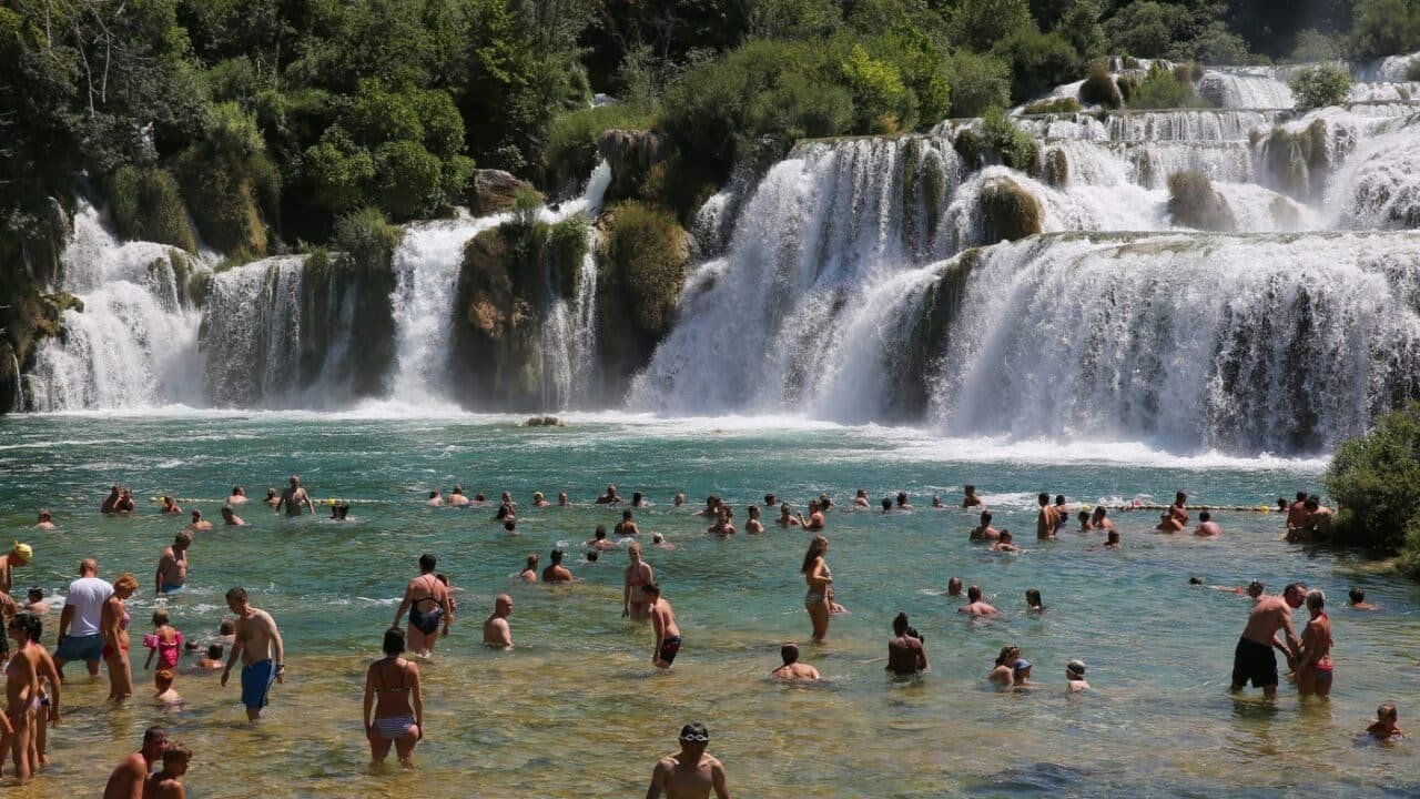 Десятки купающихся туристов у водопадов национального парка Крка