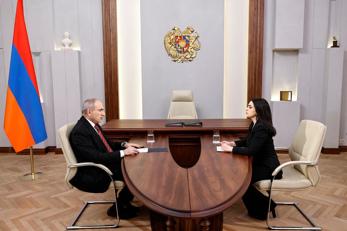 Рабочая встреча в правительственном кабинете Армении: герб республики и национальный флаг на фоне