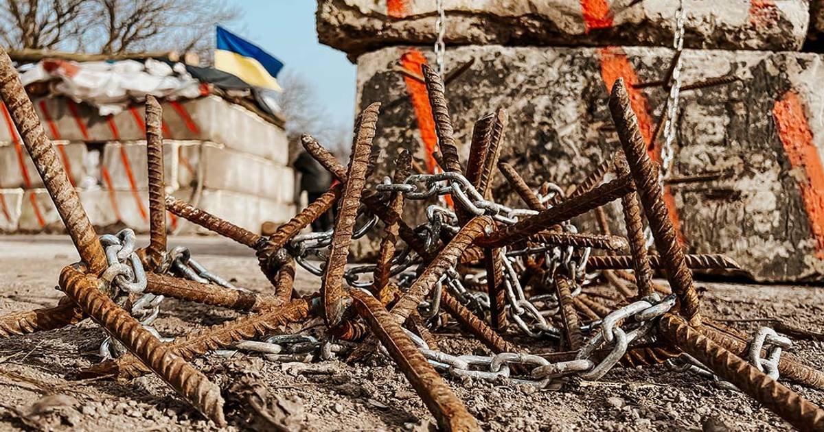 Украинские оборонительные укрепления с ежами и украинским флагом — иллюстрация цены войны