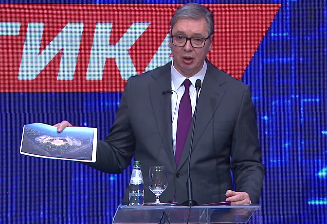 Вучич на трибуне показывает фотографию во время презентации стратегии «Сербия 2030»