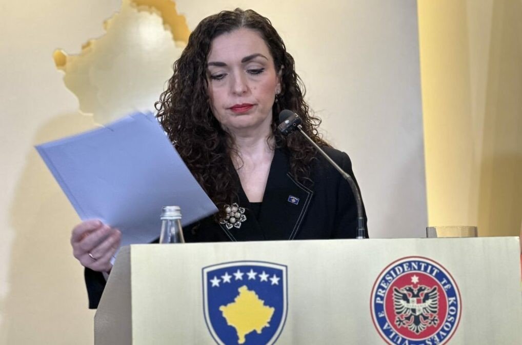 Президент Косово Вьоса Османи зачитывает указ о роспуске парламента за трибуной с президентской символикой