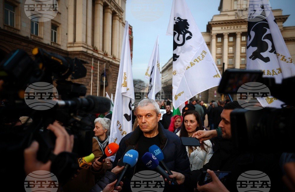Лидер партии «Възраждане» Костадин Костадинов на протесте у здания Совета министров в Софии, окружённый журналистами и сторонниками с партийными флагами