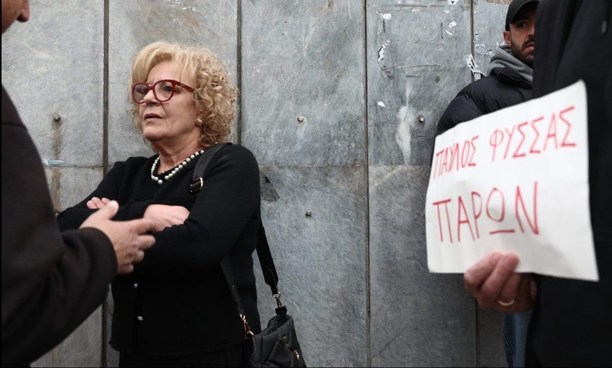 Магда Фисса, мать убитого антифашистского рэпера Павлоса Фиссаса, у здания суда. Рядом — плакат «Павлос Фиссас — здесь»