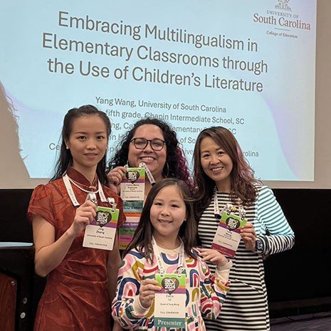 Участницы конференции о многоязычии в начальных школах в Университете Южной Каролины демонстрируют детскую литературу на разных языках
