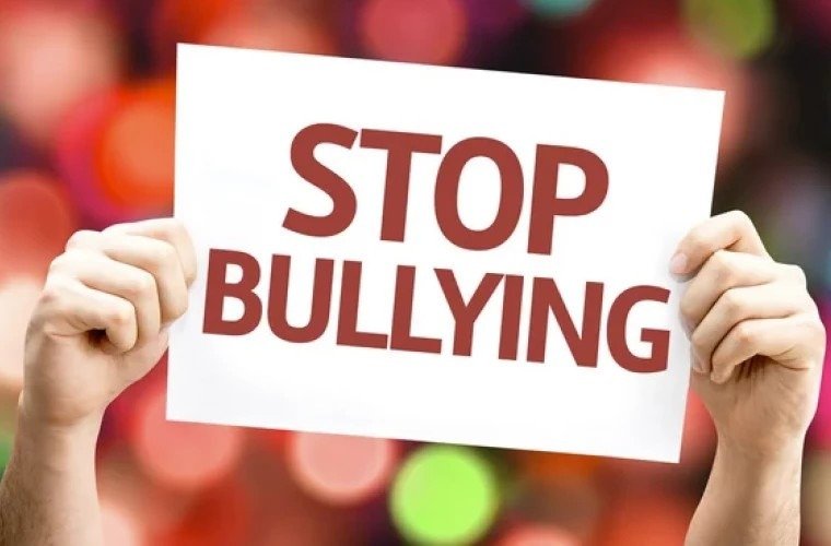 Табличка «Stop Bullying» в руках — символ борьбы с травлей в школах