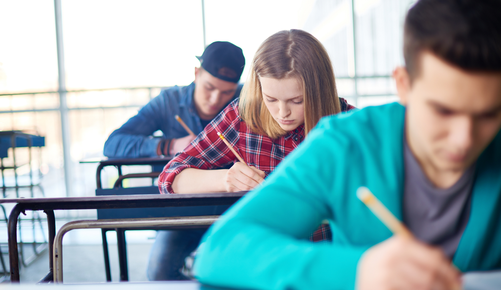 Ученики пишут за партами в школьном классе во время занятий