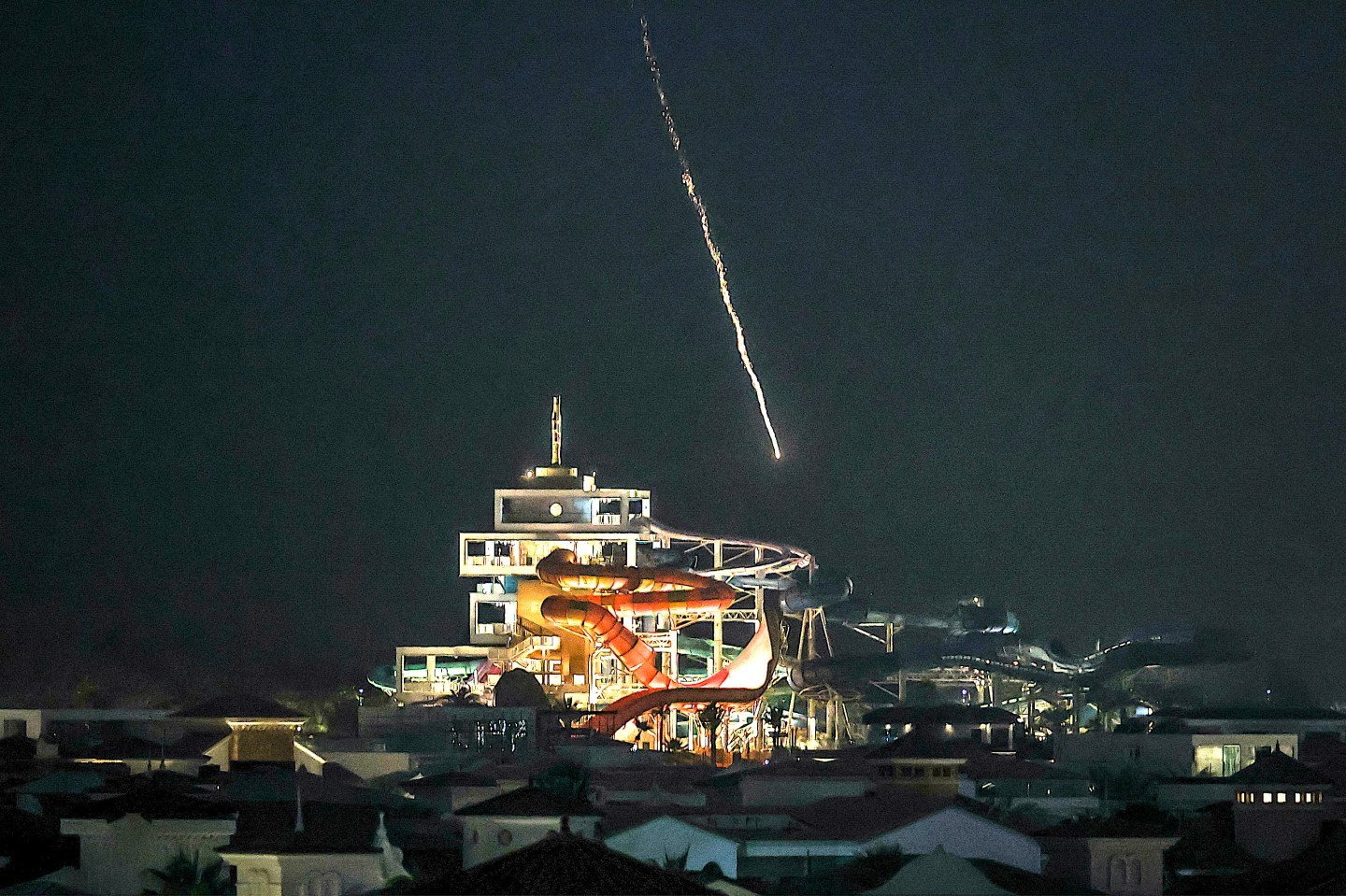 Missile or rocket trail over illuminated urban area at night. Фото: Unknown