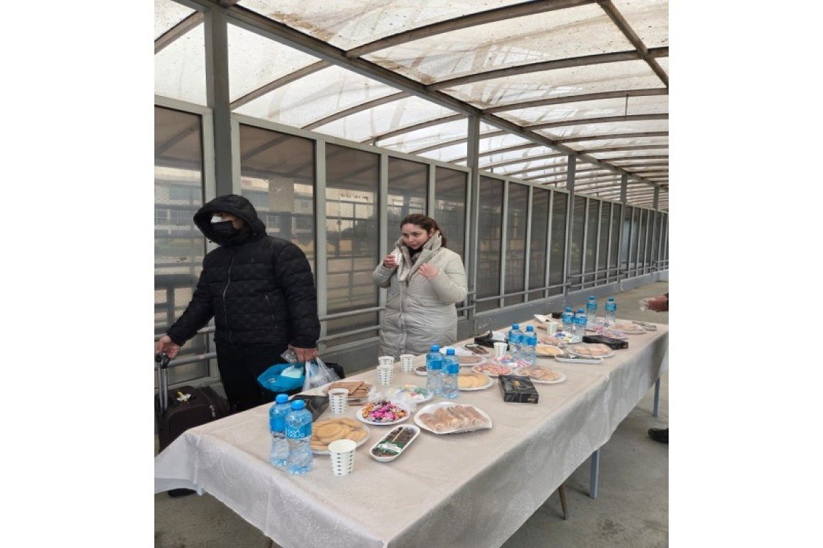 Эвакуированные получают еду и напитки за столом гуманитарной помощи в пограничном коридоре, демонстрация гостеприимства Азербайджана. Фото: APA.az