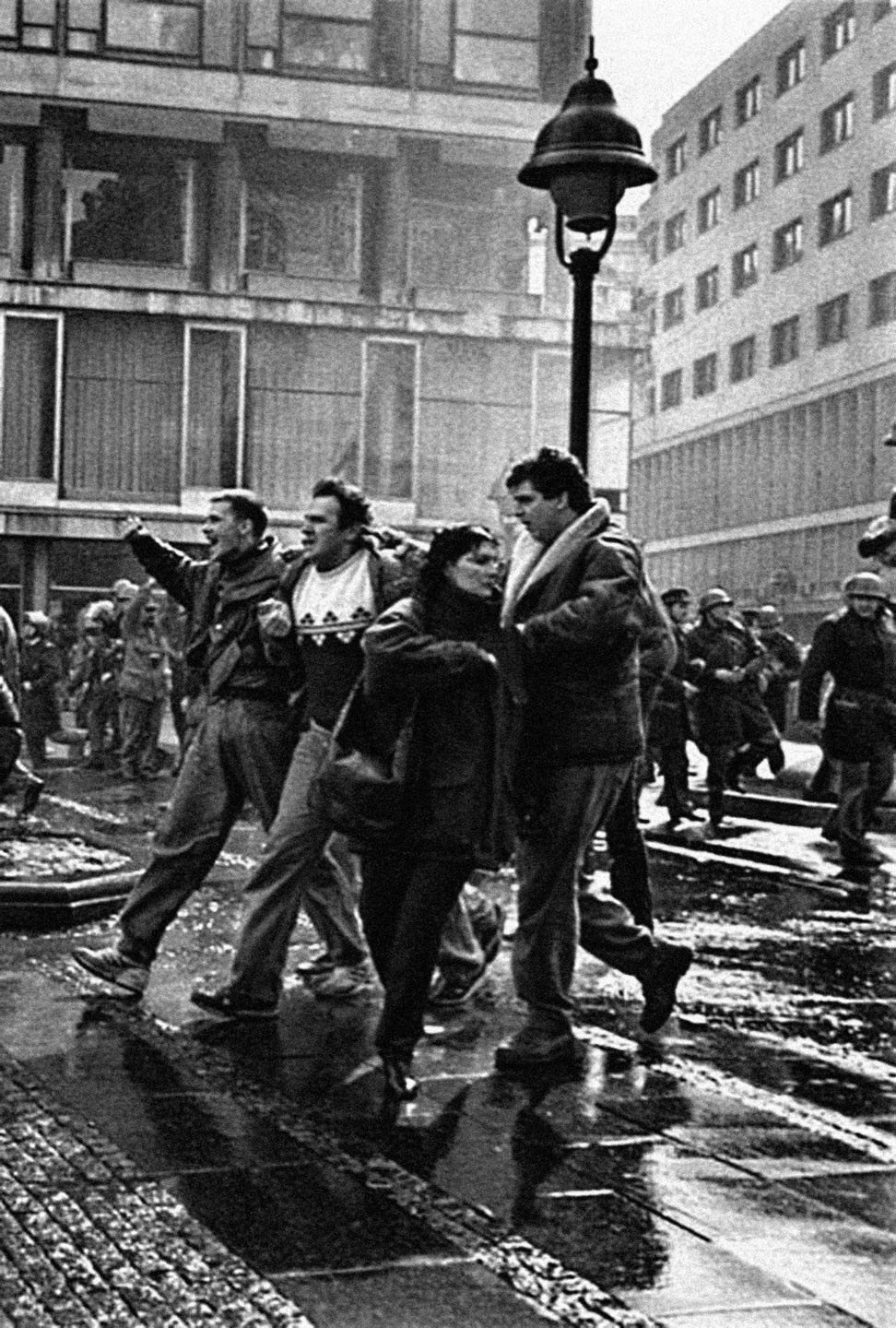 Группа молодых протестующих идёт по мокрым улицам Белграда после столкновений 9 марта 1991 года &mdash; на заднем плане видны солдаты