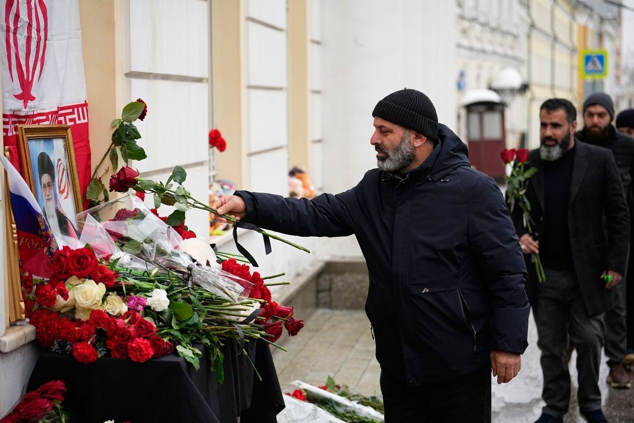 Мужчина возлагает цветы у посольства Ирана в память об убитом верховном лидере аятолле Хаменеи
