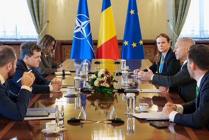 Заседание на высшем уровне в администрации президента Румынии с флагами НАТО, Румынии и ЕС на заднем плане