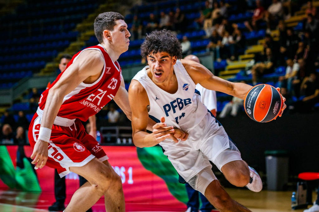 Игрок Pôle France INSEP обходит защитника Олимпиакоса с мячом на турнире NextGen Евролиги в Белграде