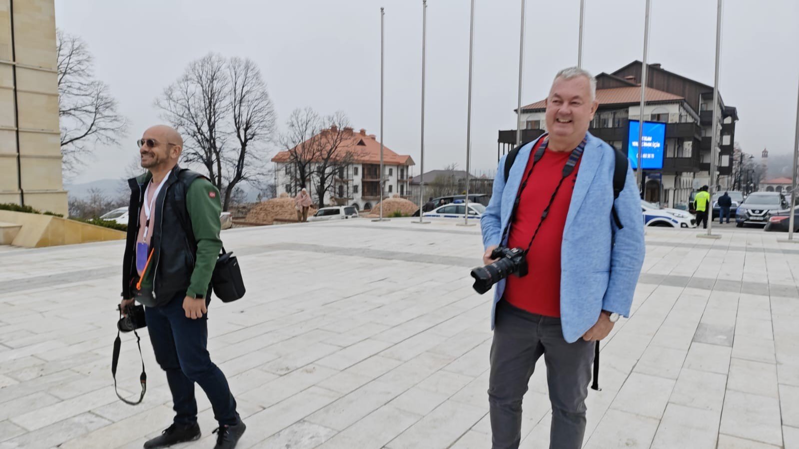 Двое путешественников с фотокамерами прогуливаются по Шуше