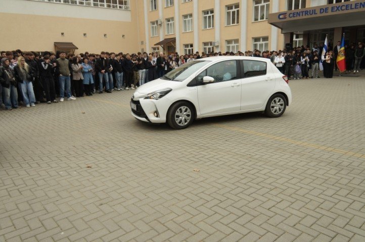 Один из переданных автомобилей Toyota Yaris на площадке Центра передового опыта в транспорте в окружении учащихся