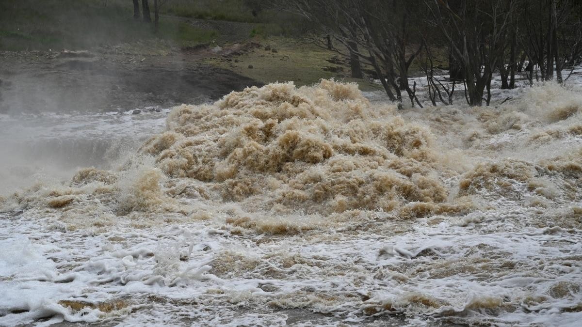 Бурное течение реки с мутной водой, вышедшей из берегов