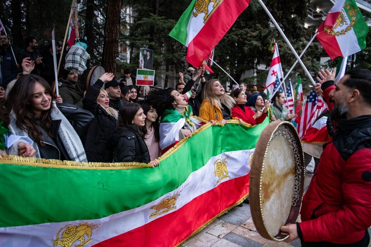 Участники акции протеста в Тбилиси с флагами иранской оппозиции и грузинскими флагами