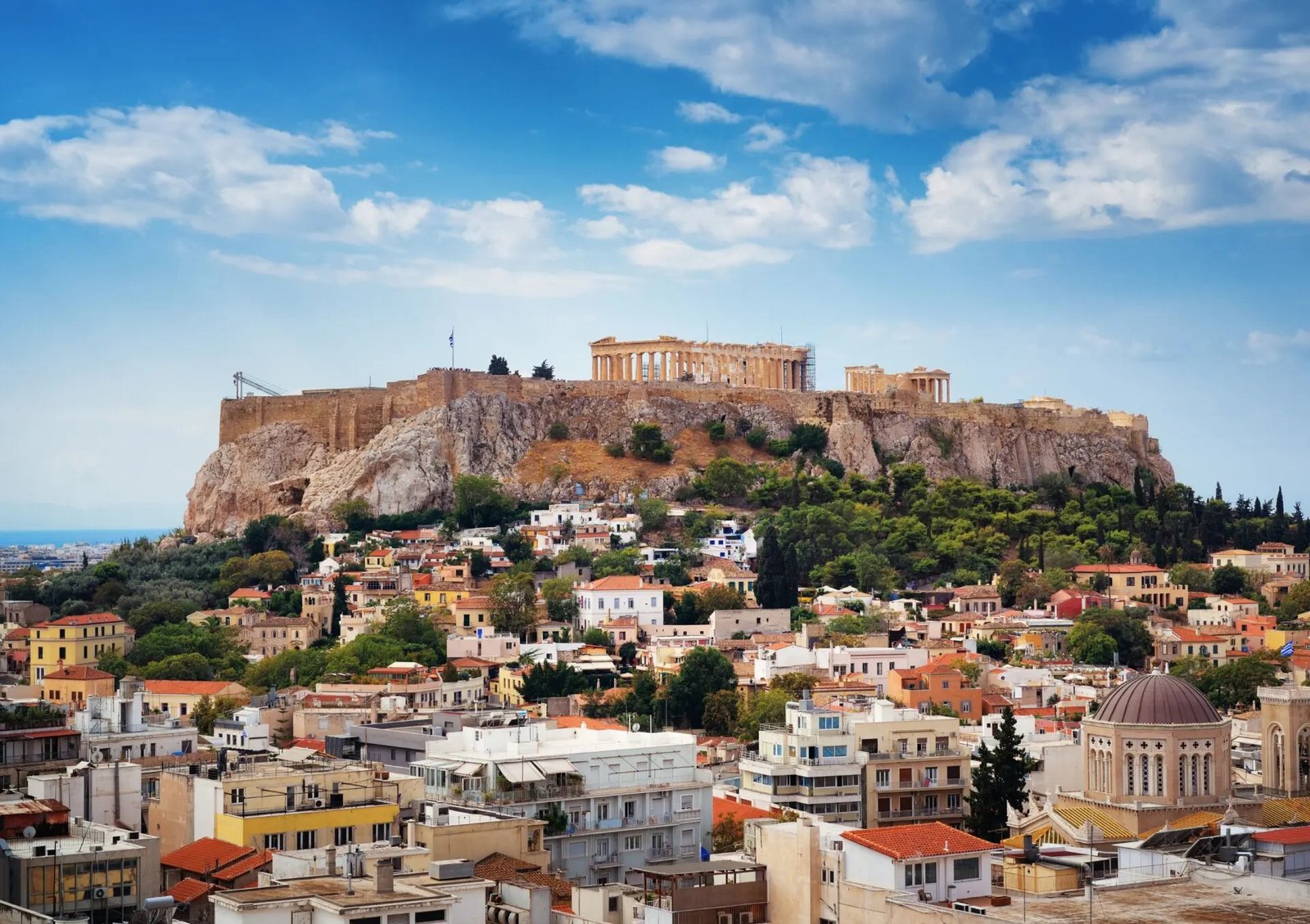 Панорамный вид на Афины с Акрополем и Парфеноном на вершине холма в окружении жилых кварталов города