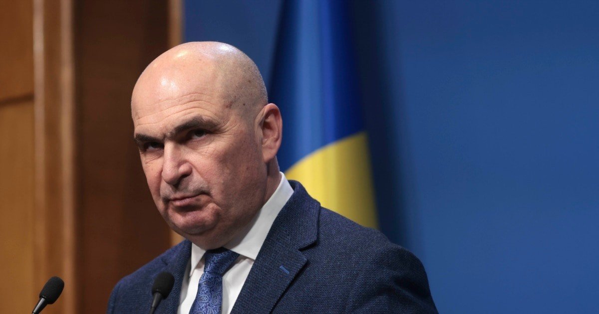 Премьер-министр Румынии Илие Боложан выступает на пресс-конференции на фоне румынского флага