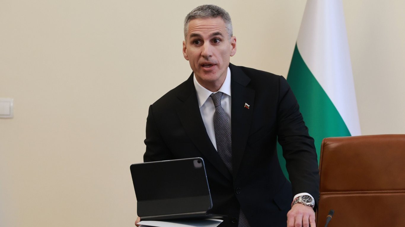 Болгарский чиновник за рабочим столом на фоне государственного флага Болгарии