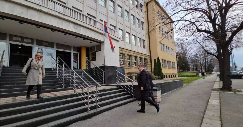 Здание сербского правосудия — государственный флаг у входа, люди на ступенях