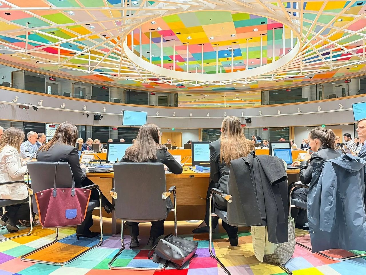 Зал заседаний Совета ЕС с характерным цветным потолком, чиновники за круглым столом. Фото: Unknown