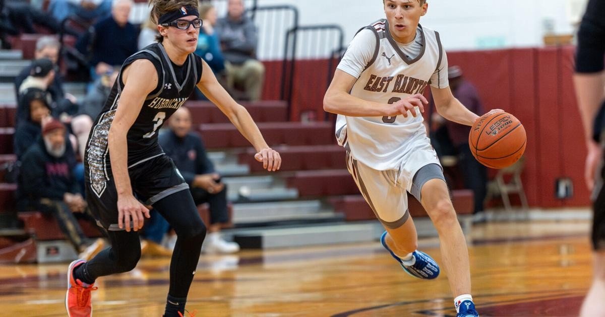 Баскетболист Ист-Хэмптона обходит защитника соперника во время домашнего матча