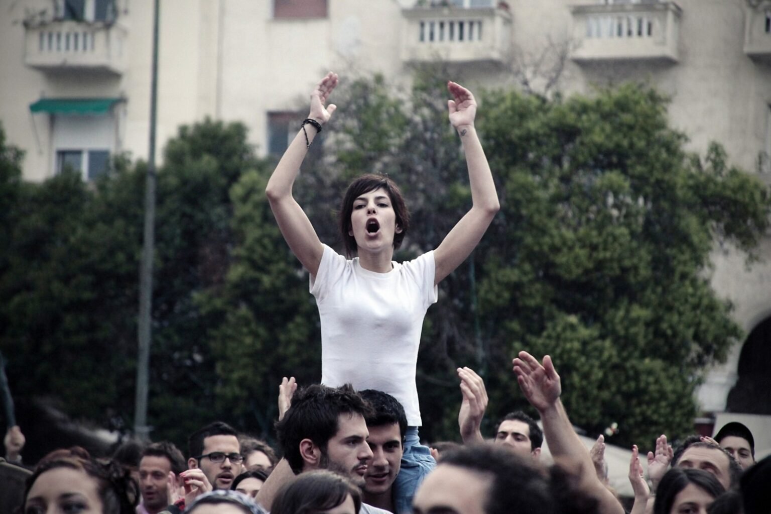 Женщина с поднятыми руками на протестном митинге в Греции