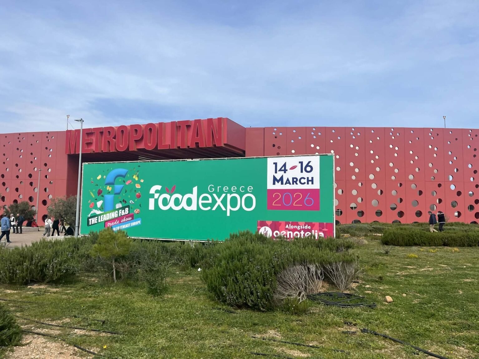 Здание выставочного центра Metropolitan Expo в Афинах с крупным баннером FOOD EXPO Greece 2026 с указанием дат проведения 14–16 марта