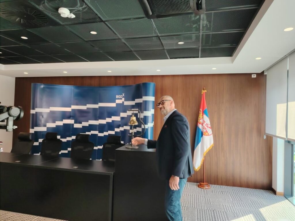 Белградская биржа открывает школу для журналистов Церемония открытия торгов в новом зале Белградской биржи с использованием традиционного биржевого колокола на фоне логотипа BGDX и государственного флага Сербии