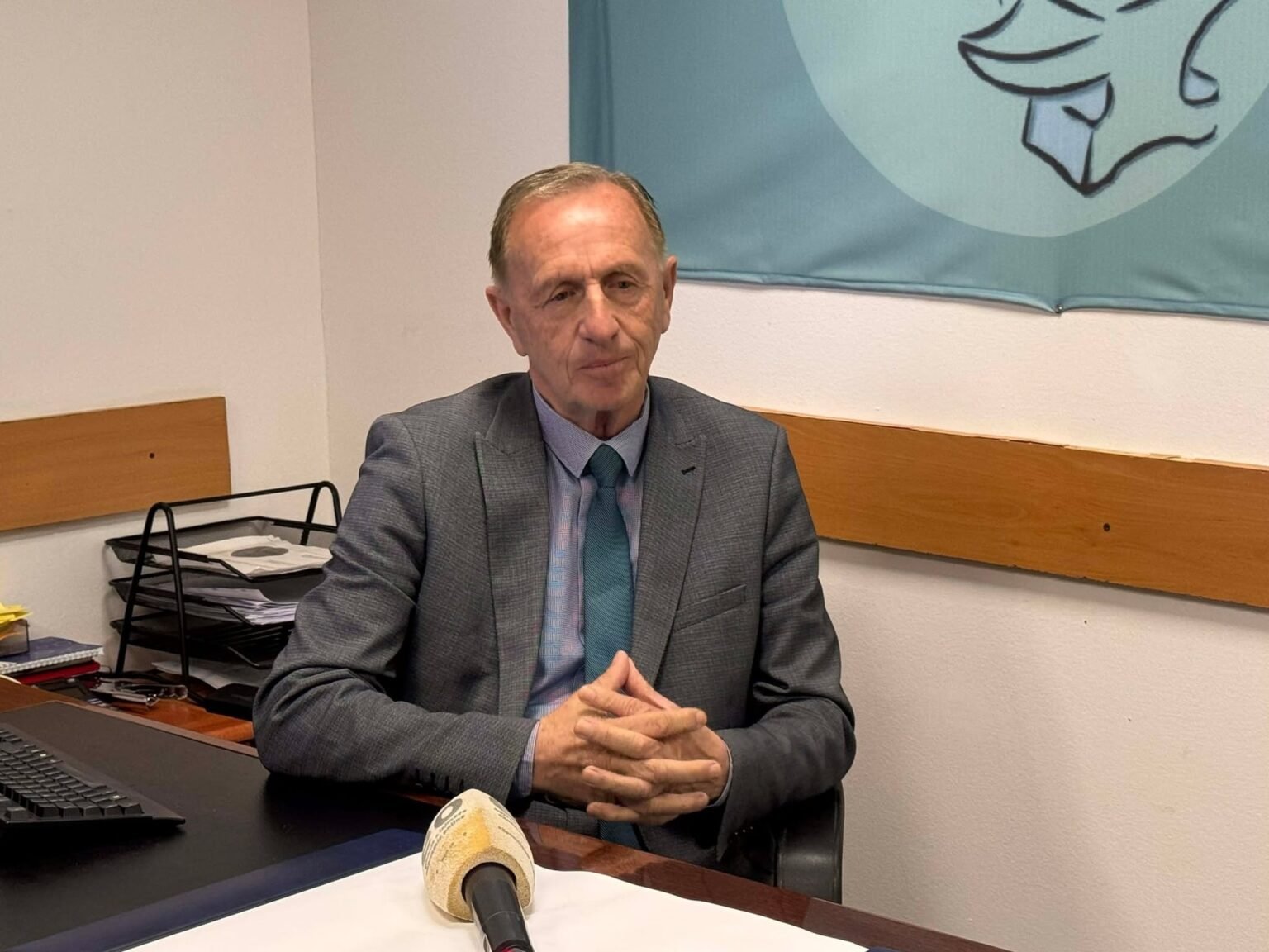 Юсуф Аземи, председатель профсоюза технического персонала Приштинского университета, за рабочим столом во время интервью