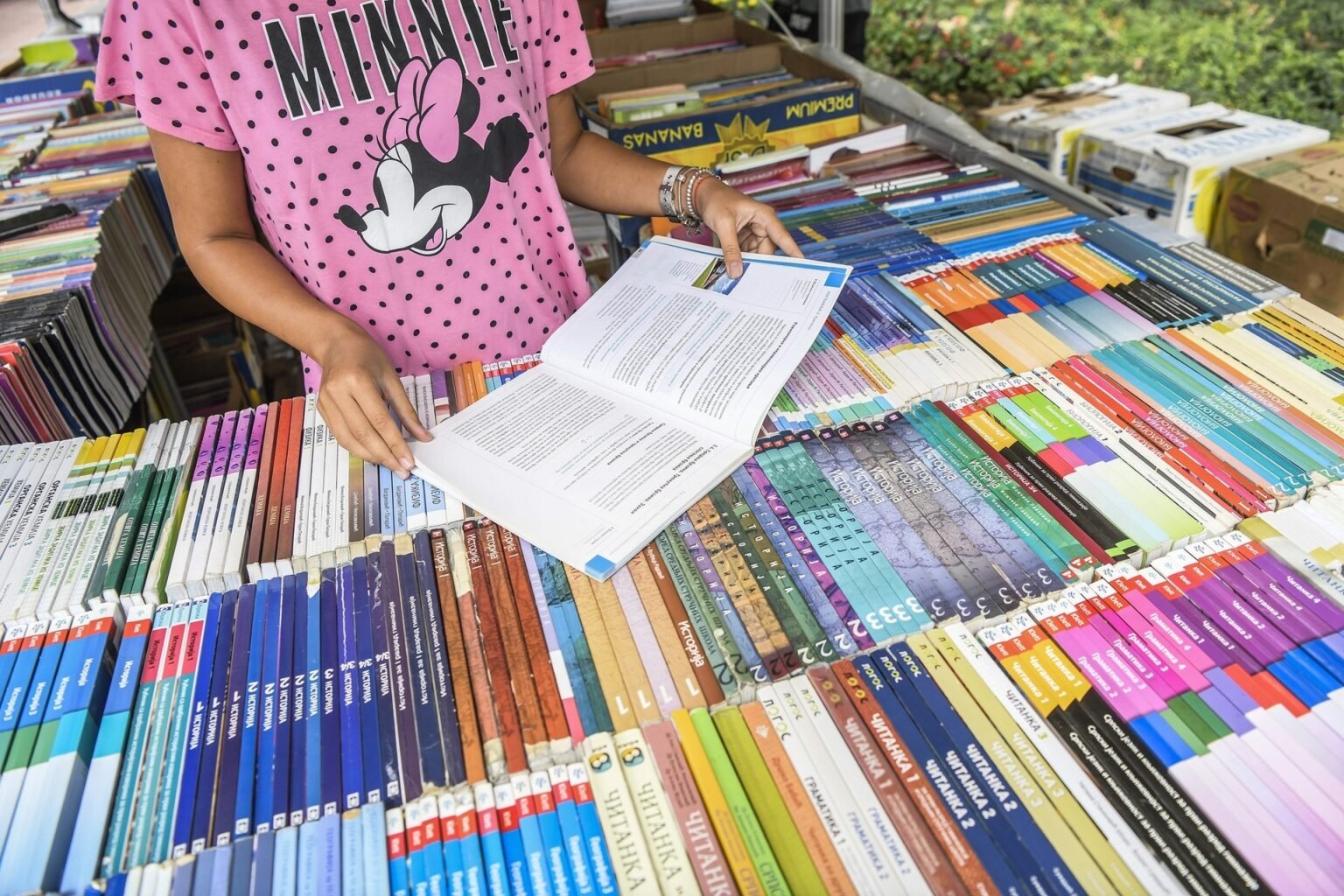 Девочка выбирает учебники на книжном развале