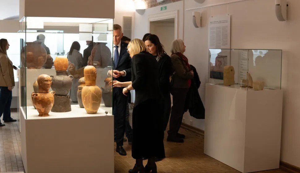 Посетители у витрины с этрусскими канопами на выставке в Археологическом музее Осиека