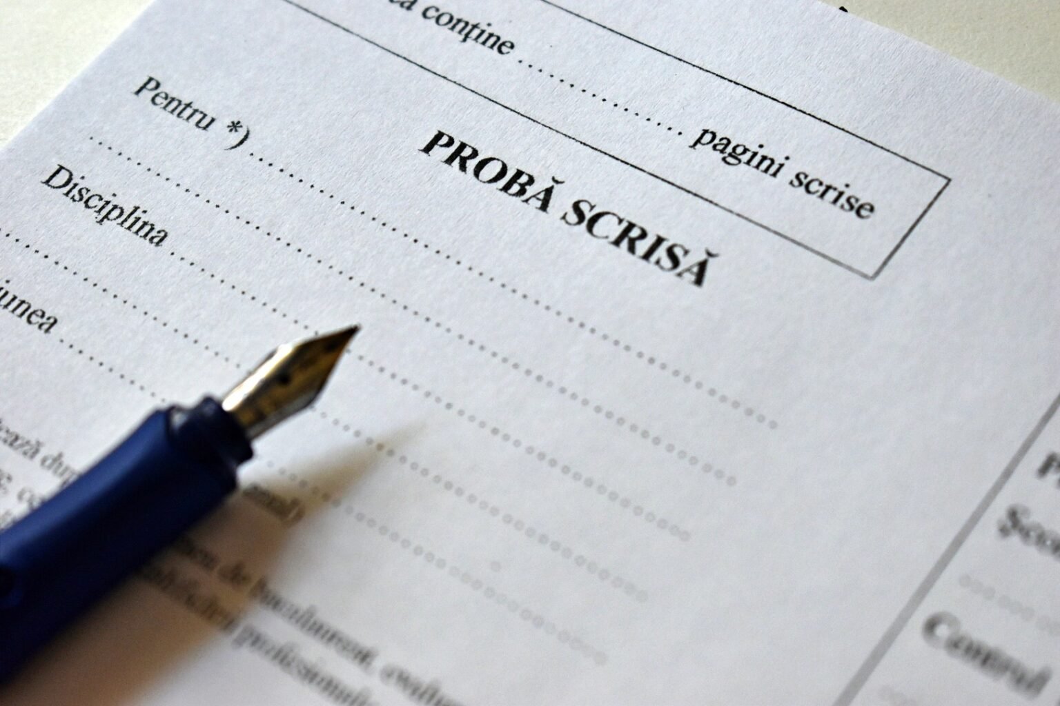 Симуляция Бакалавриата-2026: 143 тысячи учеников сдают пробный экзамен Крупный план экзаменационного бланка с надписью «PROBĂ SCRISĂ» и перьевой ручкой на столе во время пробного экзамена «Бакалавриат» в Румынии