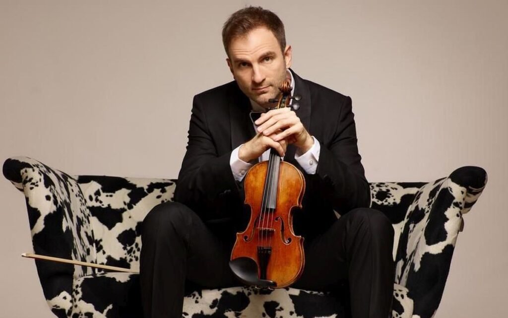 «Блиско!»: бесплатный фестиваль камерной музыки в Нови-Саде Сербский скрипач Стефан Миленкович позирует со скрипкой в руках, сидя на диване