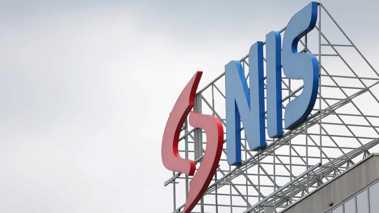 Сделка по NIS под угрозой: иранские удары по ОАЭ ставят под вопрос участие ADNOC NIS corporate sign on building rooftop with red and blue logo. Фото: Balkan Insight