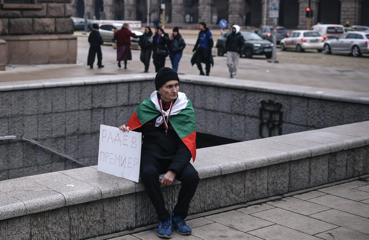 Болгария перед выборами: партии делят карту кандидатов Сторонник Румена Радева с болгарским флагом и плакатом «Радев Премиер» в центре Софии